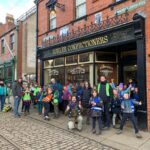 Cubs smiling outside an old shop